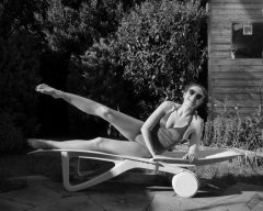 Estella Rose in purple swimsuit exercising in the garden