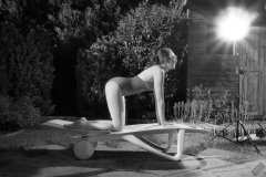 Estella Rose in purple swimsuit exercising in the garden