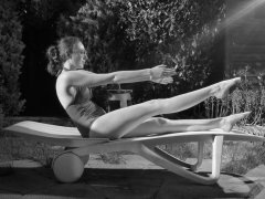 Estella Rose in purple swimsuit exercising in the garden