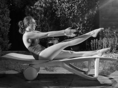 Estella Rose in purple swimsuit exercising in the garden