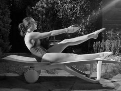 Estella Rose in purple swimsuit exercising in the garden