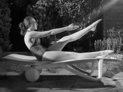 Estella Rose in purple swimsuit exercising in the garden
