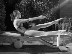 Estella Rose in purple swimsuit exercising in the garden