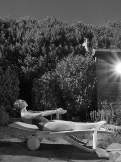 Estella Rose in purple swimsuit exercising in the garden
