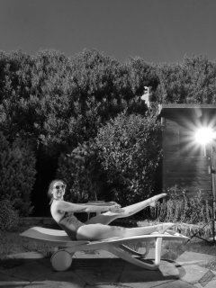 Estella Rose in purple swimsuit exercising in the garden