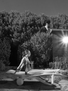 Estella Rose in purple swimsuit exercising in the garden