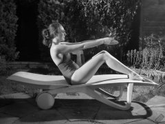 Estella Rose in purple swimsuit exercising in the garden