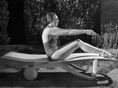 Estella Rose in purple swimsuit exercising in the garden