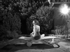 Estella Rose in purple swimsuit exercising in the garden