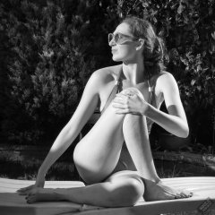 Estella Rose in purple swimsuit exercising in the garden