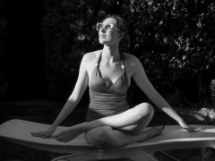 Estella Rose in purple swimsuit exercising in the garden