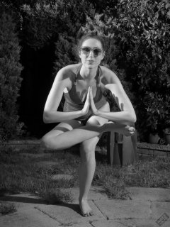 Estella Rose in purple swimsuit exercising in the garden