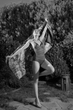Estella Rose in purple swimsuit exercising in the garden