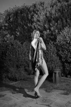 Estella Rose in purple swimsuit exercising in the garden