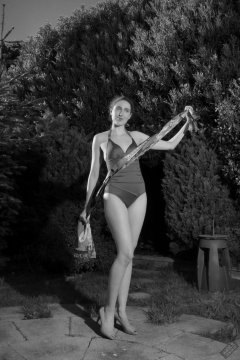Estella Rose in purple swimsuit exercising in the garden