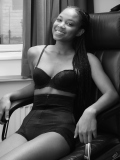 Caleann relaxes in  black bra top and black waist-trainer control-briefs, worn as hotpants