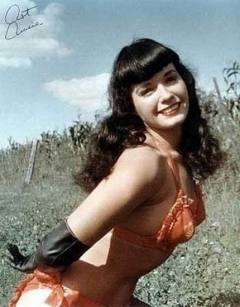 Bettie Page posing in red and gold swimsuit