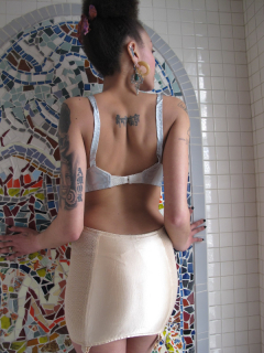 Tattooed model in white roll-on girdle