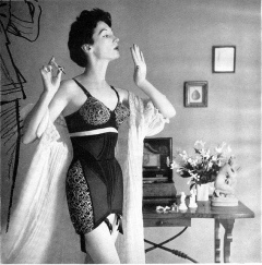Woman in tight zip-front girdle, painting her nails
