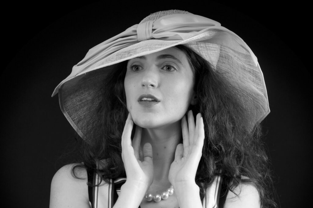 Estella Rose in her own vertical-striped jump suit and straw hat